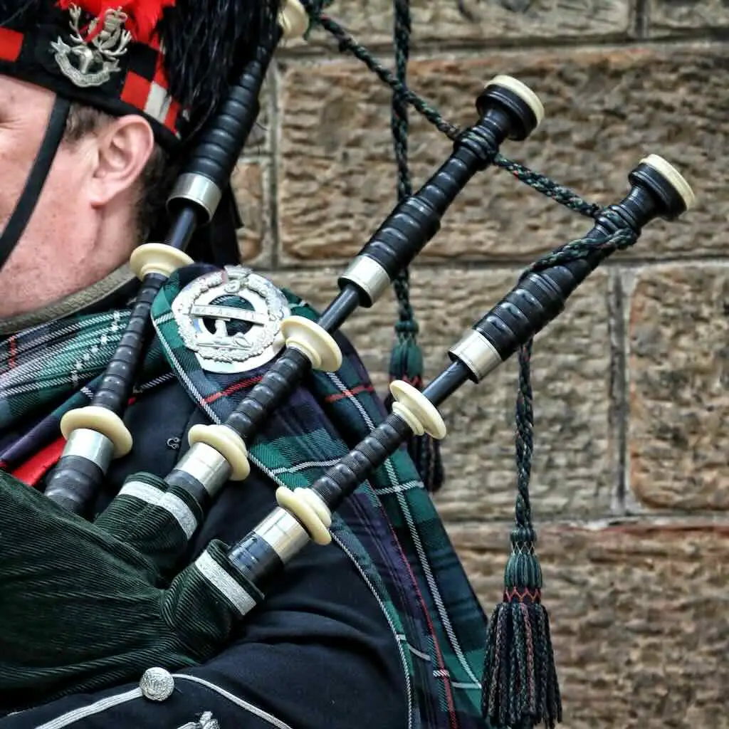A bagpiper performing a dignified musical tribute